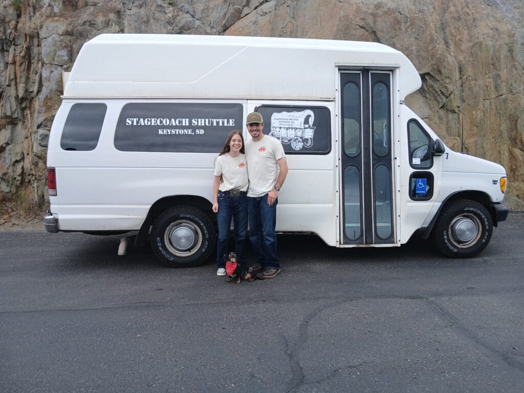 Chris and Mackenzie Owners of Stagestop Shuttle, stand in front of Shuttle Bus.