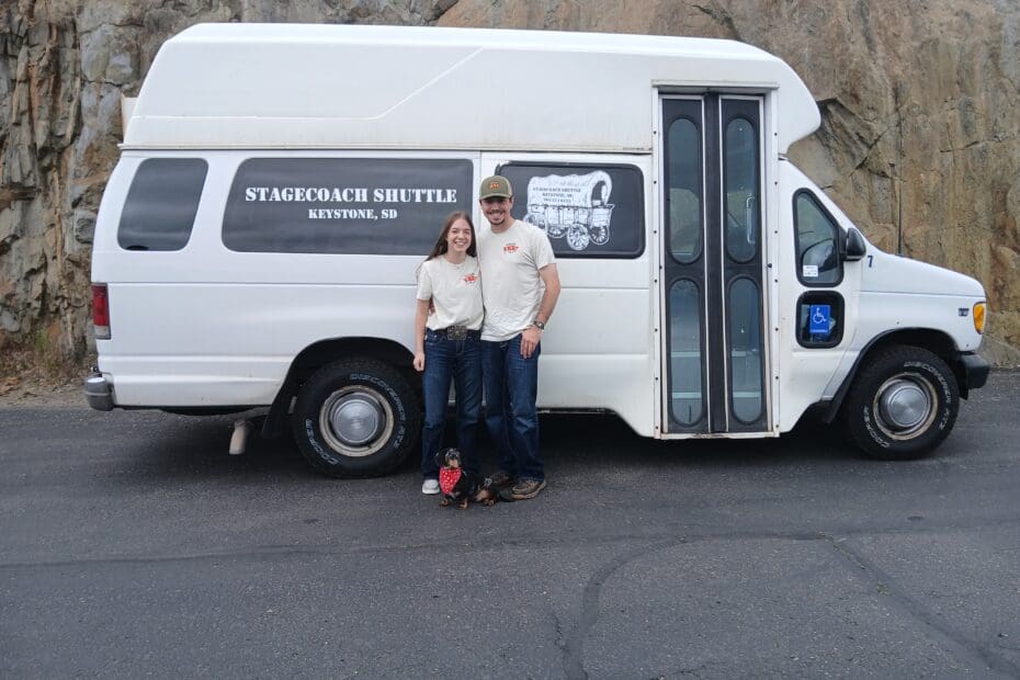 Chris and Mackenzie Owners of Stagestop Shuttle, stand in front of Shuttle Bus.